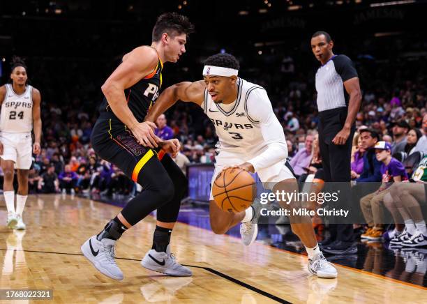 Keldon Johnson of the San Antonio Spurs looks to drive around Grayson Allen of the Phoenix Suns during the first quarter of an NBA game at Footprint...