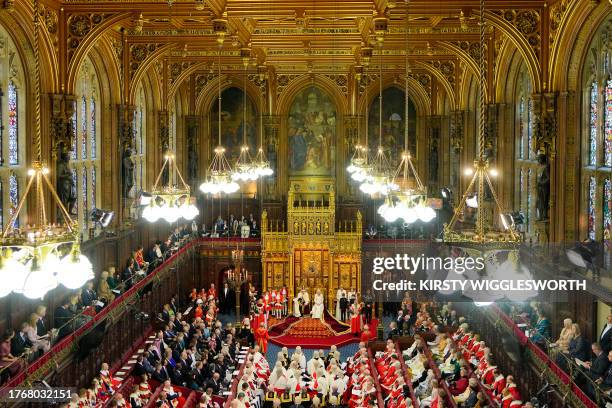 Britain's King Charles III, wearing the Imperial State Crown and the Robe of State, and Britain's Queen Camilla, wearing the George IV State Diadem,...