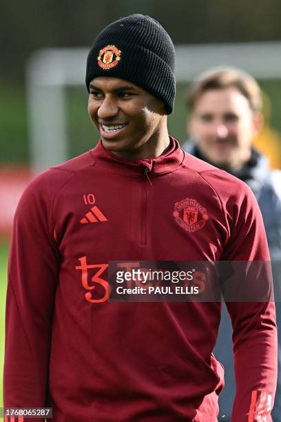 Manchester United's English striker Marcus Rashford smiles as he attends a training session at the Carrington Training Complex in Manchester,...