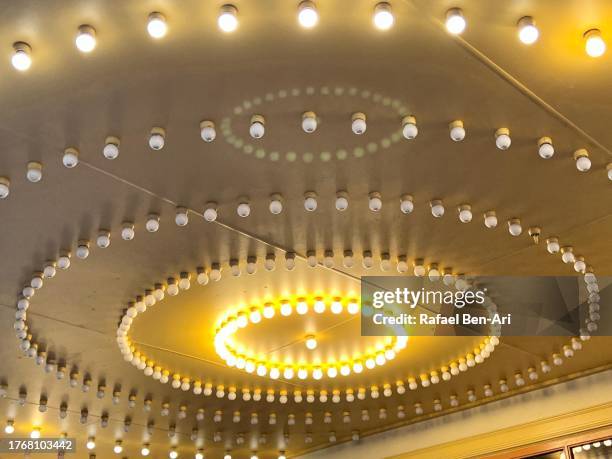 theater ceiling with retro flashing marquee lights - bronze lamp dark background stock pictures, royalty-free photos & images