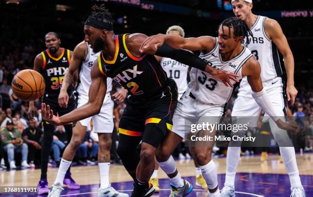 Josh Okogie of the Phoenix Suns battles Tre Jones of the San Antonio Spurs for a rebound during the fourth quarter of an NBA game at Footprint Center...