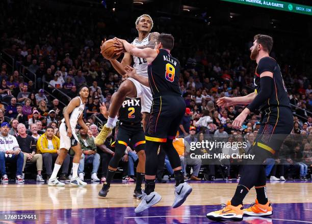 Jeremy Sochan of the San Antonio Spurs is fouled by Grayson Allen of the Phoenix Suns during the first quarter of an NBA game at Footprint Center on...