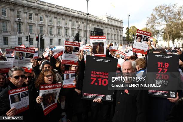 People hold up posters of the kidnapped as they take part in a vigil to remember the victims of the Hamas attack a month ago on October 7 and call...