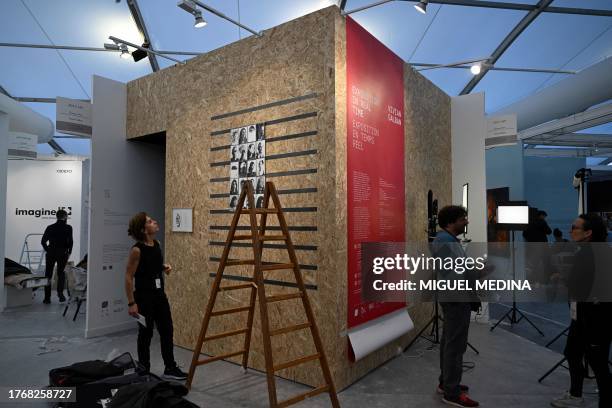 Staff work near a giant camera obscura installed by Argentinian photographer Vivian Galban at a stand, two days before the opening of Paris Photo...