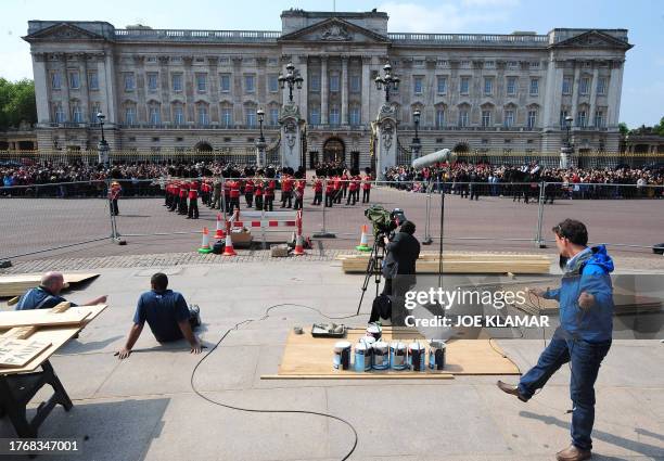 Crew works as members of the household brigade marching band walk in front of Buckingham palace, in London, on April 28, 2011. Britain's Prince...