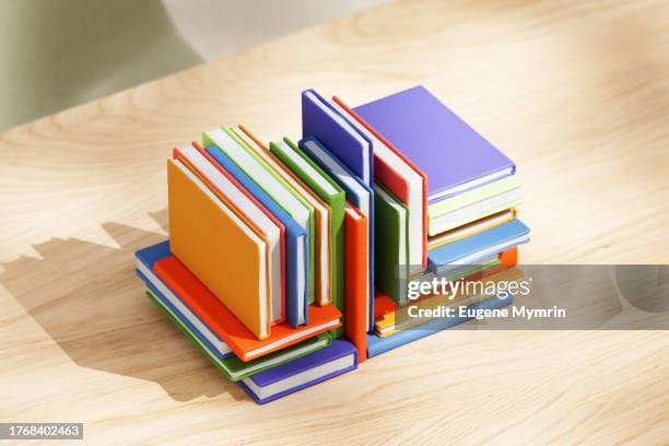 stack of multicolored books on table - libro rilegato foto e immagini stock