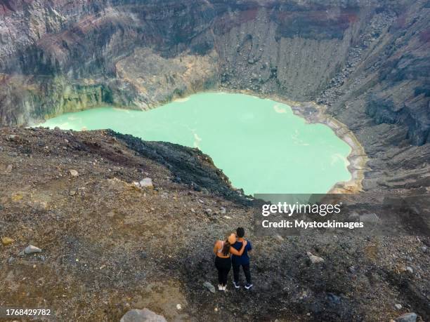 couple contemplating a volcano crater - el salvador aerial stock pictures, royalty-free photos & images