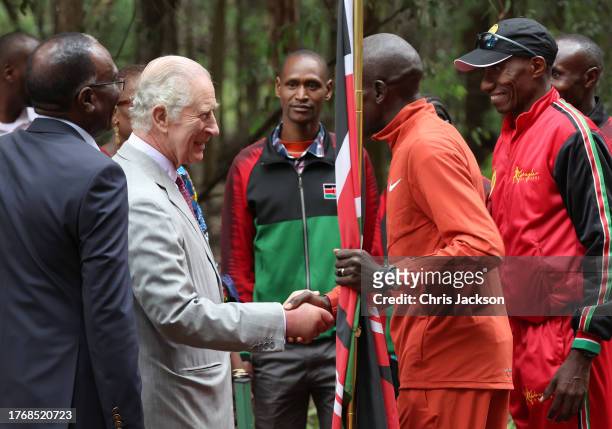King Charles III shakes hands with Kenyan marathon runner Eliud Kipchoge, ahead of the start of a 15km "Run for Nature" event during a visit to...