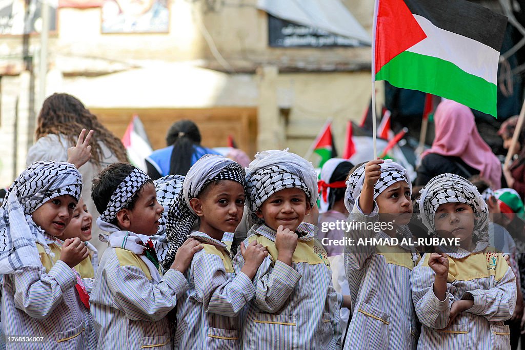 Palestinian Features A schoolboy holds a Palestinian flag as he stands with others wearing ...