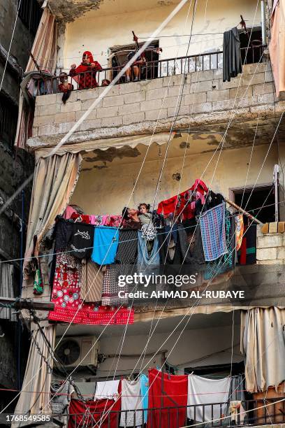 People stand along balconies airing drying laundry in a building at the Shatila camp for Palestinian refugees in the southern suburb of Beirut on...