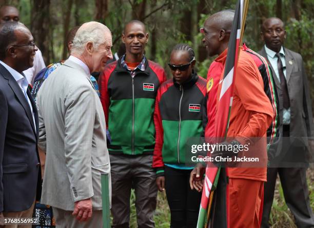 King Charles III speaks with Kenyan marathon runner Eliud Kipchoge, ahead of the start of a 15km "Run for Nature" event during a visit to Karura...