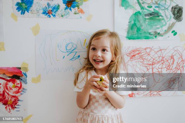 ritratto di una ragazza felice che mangia una mela a casa - kids space drawing foto e immagini stock