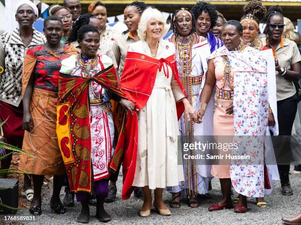 Queen Camilla is presented with a painting as she meets with children who are members of school Donkey Care Clubs, who are taking part in a craft...