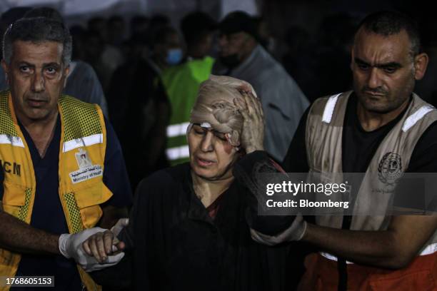 Image contains graphic content.) Medics bring an injured Palestinian woman to the Al-Shifa hospital in Gaza City, Gaza, on Monday, Nov. 6, 2023....