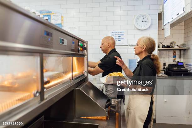family-owned chip shop in action - older man real life stock pictures, royalty-free photos & images