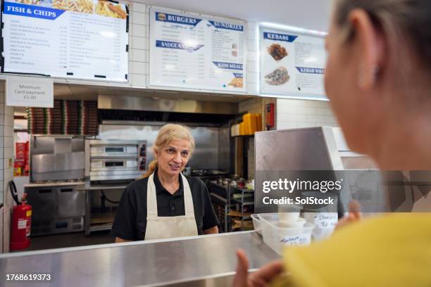 atender al cliente en la tienda de patatas fritas - fast food menu fotografías e imágenes de stock