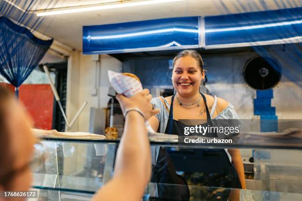 food service worker serving gyros to a young man on the street - greek food stock pictures, royalty-free photos & images