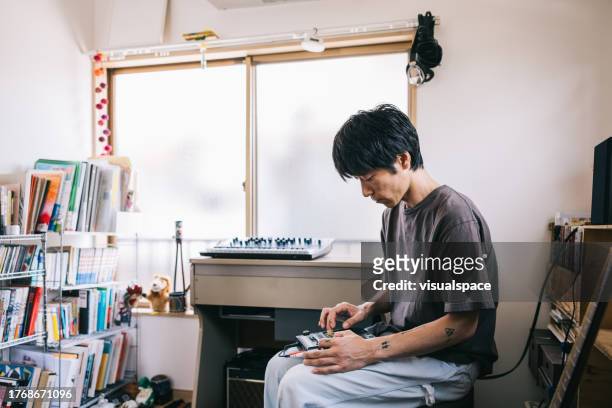 jeune producteur de musique japonais travaillant à domicile - songwriter photos et images de collection