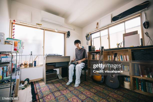 jeune producteur de musique japonais travaillant à domicile - songwriter photos et images de collection