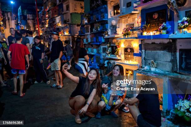 Filipinos visit the graves of departed loved ones as they mark All Saints' Day at Barangka Municipal Cemetery on November 01, 2023 in Marikina, Metro...