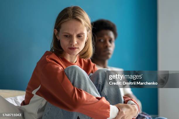 upset confused frustrated multi ethnic girl guy sitting in bed after quarrel offended each other. - relationship difficulties stock pictures, royalty-free photos & images