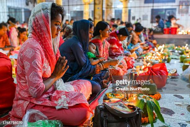Hindu devotees sit together with Prodip and pray to God in front of Shri Shri Lokanath Brahmachari Ashram temple during the religious festival Kartik...