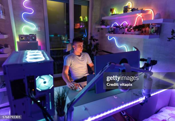 adolescente che gioca di notte - person on computer in dark room foto e immagini stock