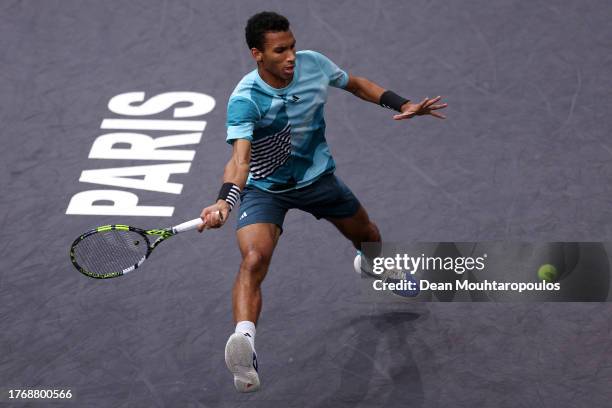 Felix Auger-Aliassime of Canada returns a forehand in his match against Stefanos Tsitsipas of Greece during Day Three of the Rolex Paris Masters ATP...