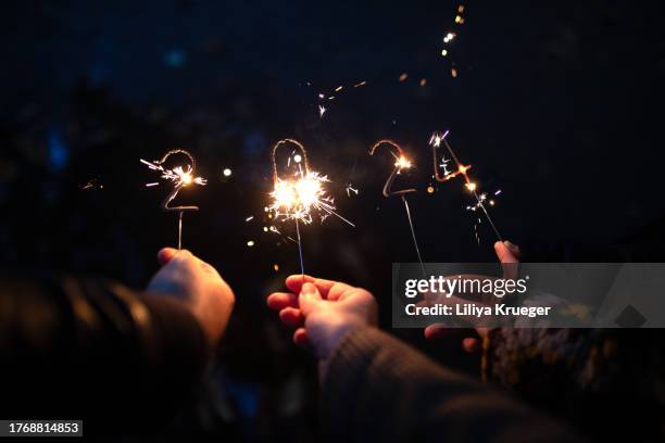 sparklers happy new year 2024 in the hands of one family. - holiday message stock pictures, royalty-free photos & images