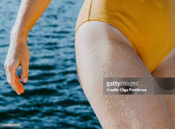 unidentified young woman in a yellow swimsuit with goosebumps all over her body - gänsehaut frau stock-fotos und bilder