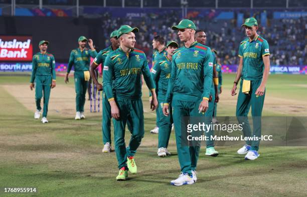 David Miller and Rassie van der Dussen of South Africa make their way off following the ICC Men's Cricket World Cup India 2023 between New Zealand...