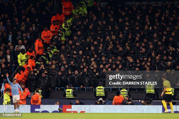 Young Boys supporters wearing black plastic bags look on as Manchester City's English midfielder Jack Grealish takes a corner kick during the UEFA...