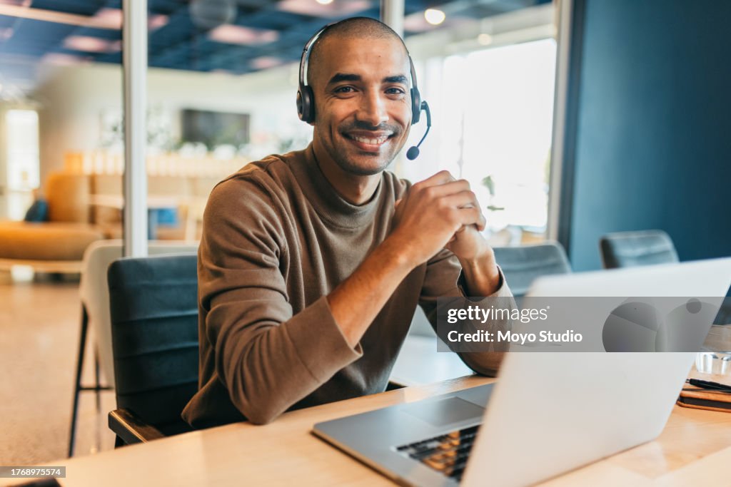 Confident businessman with headset, smiling cheerfully at camera in call center office