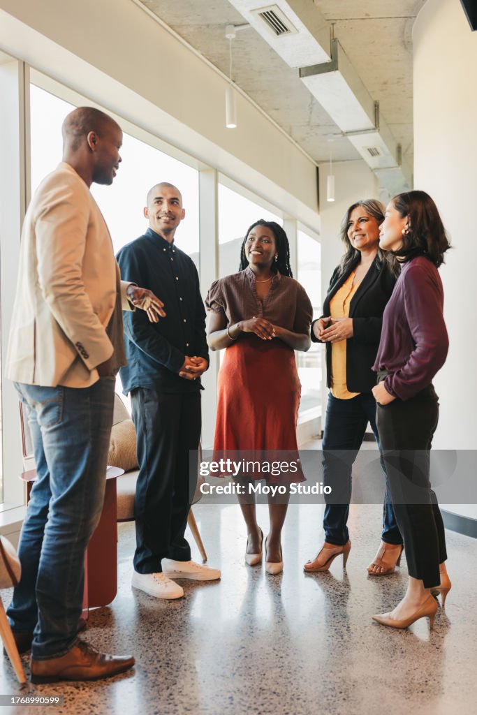 Group of multiracial business partners listening to businessman at meeting in coworking space