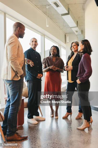 group of multiracial business partners listening to businessman at meeting in coworking space - employee engagement stock pictures, royalty-free photos & images