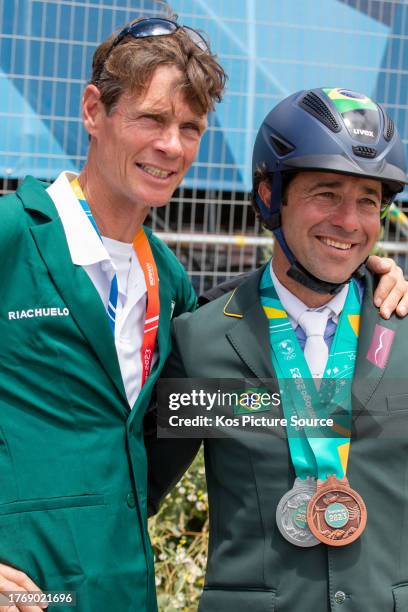 International Coach of the Brazilian Equestrian Event Team William Fox-Pitt embraces Marcio Carvalho Jorge of Brazil who took individual silver and...