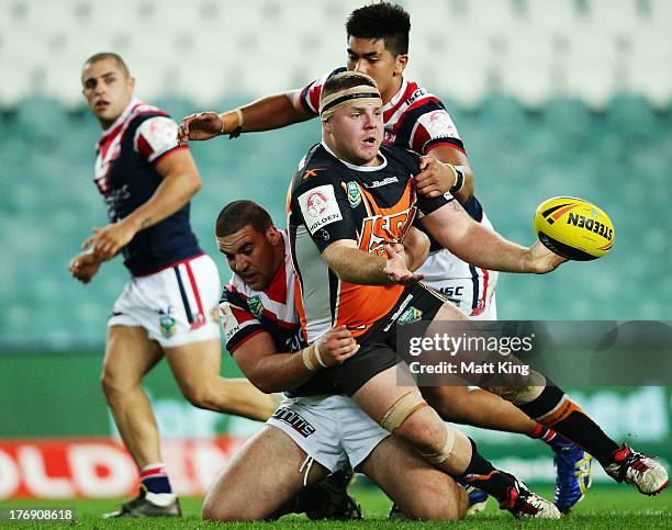 Nathan Brown of the Tigers offloads in a tackle during the round 23 Holden Cup match between the Wests Tigers and the Sydney Roosters at Allianz...