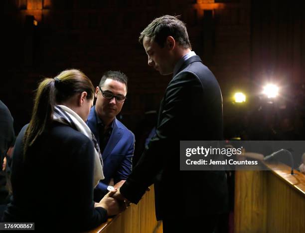 South African athlete Oscar Pistorius prays with his brother Carl Pistorius and his sister Aimee Pistorius prior to his indictment hearing in...