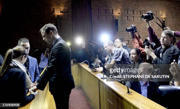 South African Paralympic sprinter Oscar Pistorius stands next to his sister Aimee and his brother Carl , as he appears at the Magistrate Court in...
