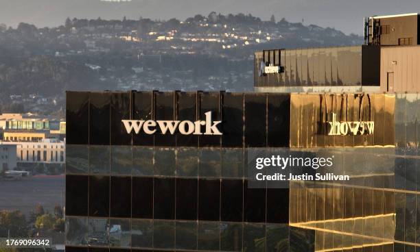 In an aerial view, a sign is posted on the exterior of a WeWork office on November 01, 2023 in San Mateo, California. Shares of WeWork dropped over...