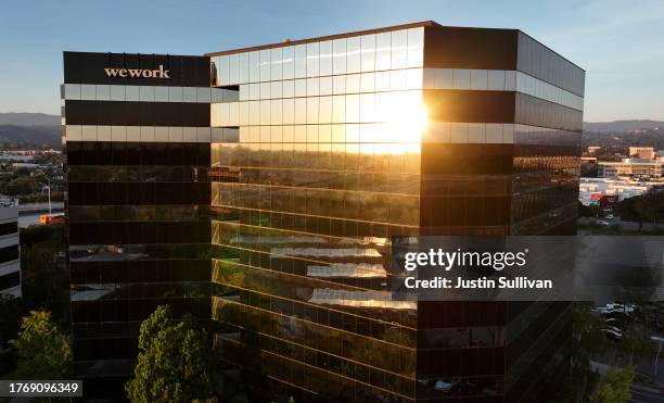 In an aerial view, a sign is posted on the exterior of a WeWork office on November 01, 2023 in San Mateo, California. Shares of WeWork dropped over...
