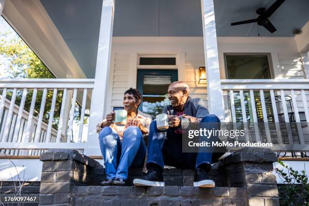 senior couple having coffee on front porch - home owner stock pictures, royalty-free photos & images