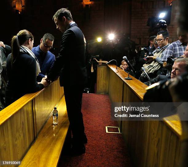 South African athlete Oscar Pistorius prays with his brother Carl Pistorius and his sister Aimee Pistorius prior to his indictment hearing in...