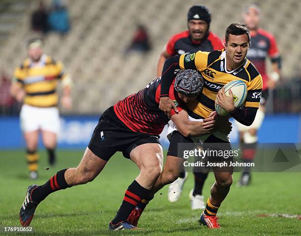 Jamison Gibson-Park of Taranaki runs with the ball in the tackle of Tyler Bleyendaal of Canterbury during the round 1 ITM Cup match between Cantebury...