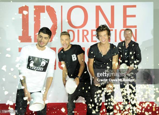 Zayn Malik, Liam Payne and Harry Styles of One Direction throw popcorn with director Morgan Spurlock at a photocall to launch their new film 'One...