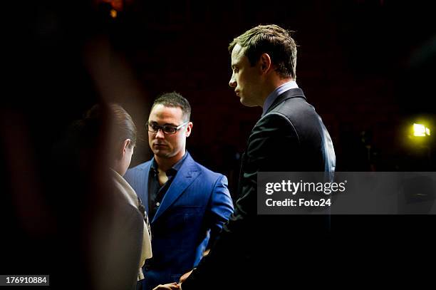 Oscar Pistorius prays with sister Aimee and brother Carl before he appears in the Pretoria Magistrates court on August 19 in Pretoria, South Africa....