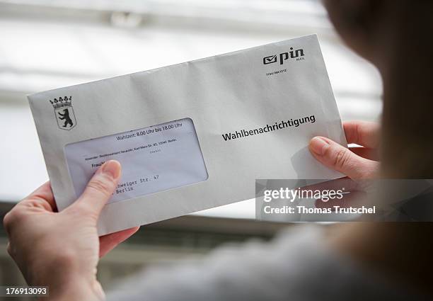 Woman holds a letter with the inscription election notification in her hands on August 19, 2013 in Berlin Germany. Every voter in Germany receives...