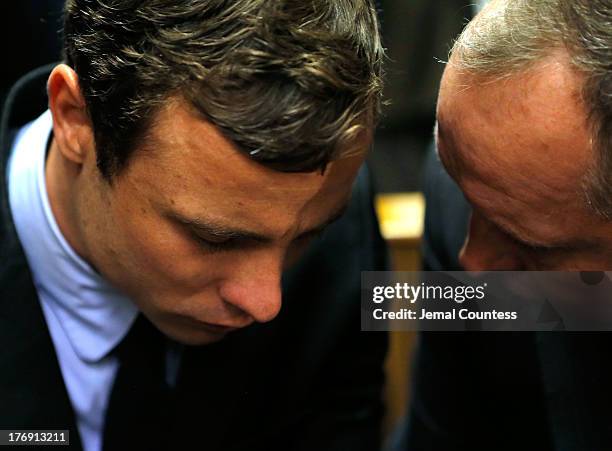 South African athlete Oscar Pistorius speaks with his lawyer Kenny Oldwage in Pretoria Magistrates Court prior to an indictment hearing on August 19,...