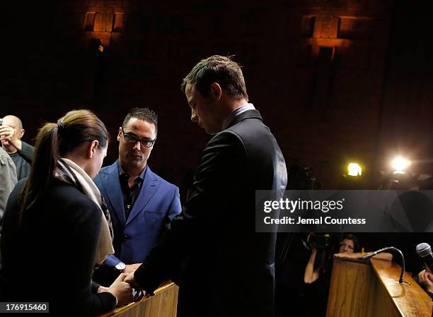 South African athlete Oscar Pistorius prays with his brother Carl Pistorius and his sister Aimee Pistorius prior to his indictment hearing in...
