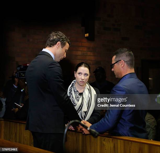 South African athlete Oscar Pistorius prays with his sister Aimee Pistorius and brother Carl Pistorius prior to his indictment hearing in Pretoria...